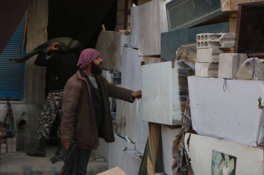 SYRIA, Harasta: Bir isyancı, Suriye 'nin başkenti Şam' ın kuzeyindeki Harasta 'da, Suriye ordusu ve müttefikleri arasında 2 Kasım 2015' te meydana gelen çatışmalar sırasında, el yapımı bir barikatla düşman varlığını kontrol ediyor.. 