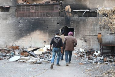SYRIA, Harasta: İsyancılar yıkılan bir binaya girerken, Suriye ordusu ve müttefikleri arasında 2 Kasım 2015 'te Suriye başkenti Şam' ın kuzeyindeki Harasta 'da çıkan çatışmalar yoğunlaştı..