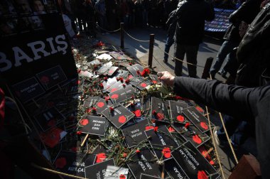 TIKLAYIN, Ankara: Yas tutanlar, 7 Kasım 2015 'te Ankara, Türkiye' de düzenlenen törende 10 Ekim bombalı saldırılarının kurbanlarının adlarını içeren çiçek ve afişler yerleştirdiler