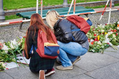 GERMANY, Berlin: Young women place candles on the floor as tens gather in front of the French embassy in Berlin, on November 14, 2015, to pay tribute to the Paris November-13 terror attacks's victims.