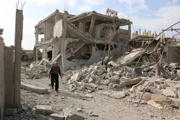 stock image SYRIA, Damascus: A Syrian man walks amid damaged buildings in the Marj al-Sultan neighborhood in eastern Damascus on October 24, 2015.