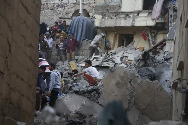 Yemenliler, 1 Kasım 2015 'te Suudi liderliğindeki koalisyonun Taiz, Yemen' deki bir yerleşim bölgesini vurması sonrasında yıkılan binaları teftiş ettiler.