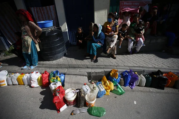 stock image NEPAL, Kathmandu : A man passing by empty containers placed in line as people wait to buy kerosene during the ongoing fuel crises that has been continuing for over a month now in Kalikasthan, Kathmandu on November, 3 2015.