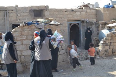 Yemen 'in başkenti Sanaa yakınlarındaki yerlerinden edilmiş ailelere ve fakirlere 11 Kasım 2015' te yerel insani yardım örgütü Mona Relief 'in üyeleri giysi dağıtıyor..