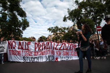 20 Kasım 2015 'te İtalya' nın Palermo kentindeki Piazza Castelnuovo 'dan Teatro Massimo' ya yüzlerce lise öğrencisinin Temmuz 2015 'te kabul edilen İyi Okul reform tasarısına karşı yürüdükleri yürüyüşte bir protestocu işaret fişeği yaktı..