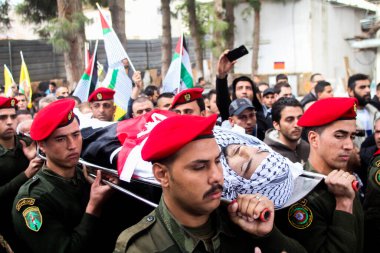 Batı BANK, Ramallah: Filistinli güvenlik görevlileri 26 Kasım 2015 'te Batı Şeria' daki Ramallah kentinde düzenlenen cenaze töreninde 16 yaşındaki İbrahim Dawood 'un cesedini taşıdılar.