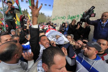 Batı BANK, Ramallah: Filistinli güvenlik görevlileri 26 Kasım 2015 'te Batı Şeria' daki Ramallah kentinde düzenlenen cenaze töreninde 16 yaşındaki İbrahim Dawood 'un cesedini taşıdılar.