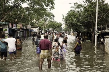 INDIA, Chennai : People wade through the water-logged road at Pattullos Road in Chennai, capital of southern Indian state Tamil Nadu, on December 3, 2015.