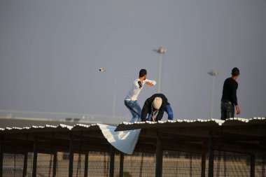 GAZA STRIP, Gazze: Filistinli protestocular, 11 Aralık 2015 'te Gazze' nin kuzeyinden geçen Filistinli gençlerle İsrail savunma askerleri arasında çıkan çatışmalarda İsrail askerleri tarafından atılan göz yaşartıcı gazdan korunmak için kaçtılar.  