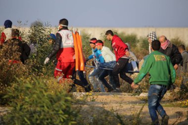 GAZA STRIP, Gazze: Filistinli protestocular, 11 Aralık 2015 'te Gazze' nin kuzeyinden geçen Filistinli gençlerle İsrail savunma askerleri arasında çıkan çatışmalarda İsrail askerleri tarafından atılan göz yaşartıcı gazdan korunmak için kaçtılar.  