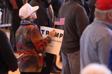 UNITED-STATES, Mesa : A campaign supporter holds up a sign for Republican presidential candidate Donald Trump as his plane arrives to a campaign event at the International Air Response facility on December 16, 2015 in Mesa, Arizona.