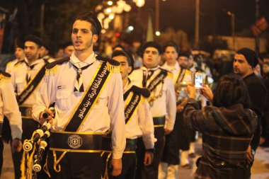 Batı BANK, Beit Sahour: Binlerce Filistinli, 17 Aralık 2015 'te Beytüllahim' in doğusundaki Beytüllahim köyünde düzenlenen Noel ağacı aydınlatma festivaline katıldı. Müzisyenler kalabalığa katılmadan önce gayda, davul ve pirinç çalardı. 