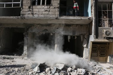 SYRIA, Saqba: 28 Aralık 2015 'te Suriye' nin başkenti Şam 'ın doğu banliyösünde yıkılan bir binayı temizleyen Saqba sakini.