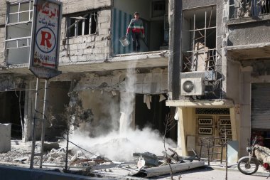 SYRIA, Saqba: 28 Aralık 2015 'te Suriye' nin başkenti Şam 'ın doğu banliyösünde yıkılan bir binayı temizleyen Saqba sakini.