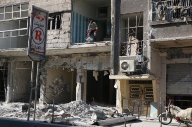 SYRIA, Saqba: 28 Aralık 2015 'te Suriye' nin başkenti Şam 'ın doğu banliyösünde yıkılan bir binayı temizleyen Saqba sakini.