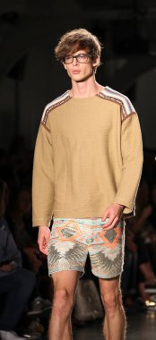 Beyaz tenli yakışıklı model podyumda yürüyor. Custo Barcelona Moda Şovu, New York Moda Haftası Yaz 2016