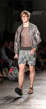 Beyaz tenli yakışıklı model podyumda yürüyor. Custo Barcelona Moda Şovu, New York Moda Haftası Yaz 2016