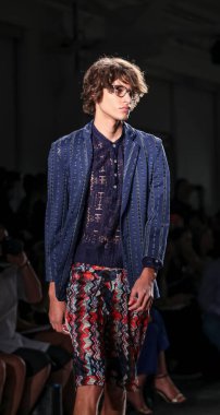 Beyaz tenli yakışıklı model podyumda yürüyor. Custo Barcelona Moda Şovu, New York Moda Haftası Yaz 2016