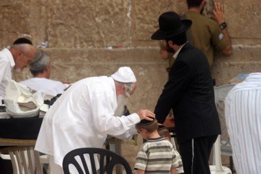 Jewish men pray at the western wall in Jerusalem