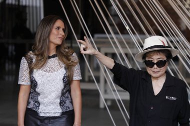 MEXICO, Mexico City: Japanese musician and artist Yoko Ono, widow of John Lennon, waves in front of a work titled 'Morning Beams/River Bed,' at a press event to mark the opening of her exhibition 'Land of Hope'  clipart
