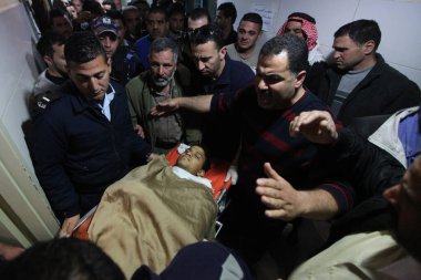 WARNING: GRAPHIC CONTENTWEST BANK, Bethlehem: Mourners gather over the body of a young Palestinian man who was killed during clashes near a border checkpoint on February 14, 2016.