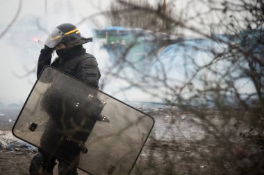 FRANCE, Calais: Göçmenler, Fransa 'nın kuzey liman kenti Calais' te 1 Mart 2016 'da kampın yarısı sökülürken, sözde Orman göçmeni kampının güney kesimindeki yanan barakaların yanından geçtiler.