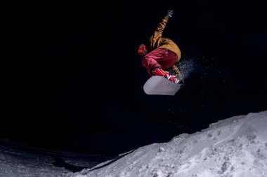 Gece vakti atlayan snowboardcu