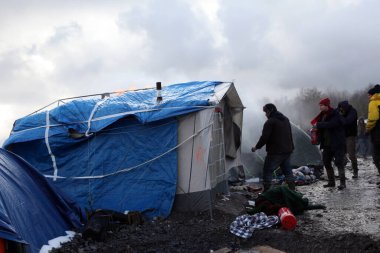 Fransa, Grande-Synthe - 7 Mart 2016: Kuzey Fransa 'nın Dunkerque kenti yakınlarındaki Grande Synthe' deki göçmen kampının dağıtılması sırasında mültecilerin resimleri çekildi, 