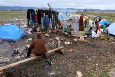 GREECE, Idomeni: 10 Mart 2016 'da Yunanistan' ın İdomeni köyü yakınlarındaki Yunan-Makedon sınırında çıkan bir şenlik ateşinde göçmenler ısınıyor 