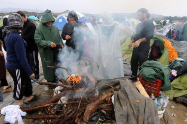 GREECE, Idomeni: 10 Mart 2016 'da Yunanistan' ın İdomeni köyü yakınlarındaki Yunan-Makedon sınırında çıkan bir şenlik ateşinde göçmenler ısınıyor 