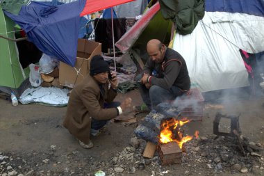 GREECE, Idomeni: 10 Mart 2016 'da Yunanistan' ın İdomeni köyü yakınlarındaki Yunan-Makedon sınırında çıkan bir şenlik ateşinde göçmenler ısınıyor 