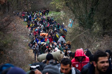 Yunanistan, Idomeni - 14 Mart 2016: Yunanistan 'ın İdomeni köyü yakınlarındaki Yunanistan-Makedonya sınırındaki derme çatma bir kamptan Makedonya' ya giden göçmenler ve mülteciler dalgalı bir nehri geçerek geçiyorlar