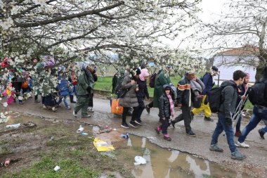 Yunanistan, Idomeni - 14 Mart 2016: Yunanistan 'ın İdomeni köyü yakınlarındaki Yunanistan-Makedonya sınırındaki derme çatma bir kamptan Makedonya' ya giden göçmenler ve mülteciler dalgalı bir nehri geçerek geçiyorlar