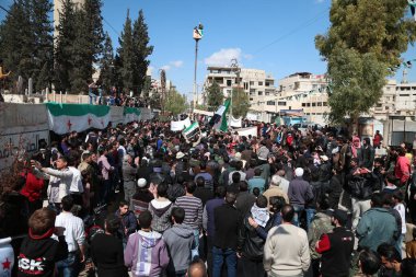 SYRIA, Saqba: Protestocular, 2011 yılındaki ayaklanma sırasında kabul edilen Baath öncesi bayrakları ve 18 Mart 2016 tarihinde Suriye başkenti Şam 'ın dış mahallelerinde, Saqba' da düzenlenen bir rejim karşıtı gösteride gösterilen pankartları ellerinde tutuyorlar..