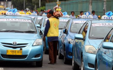 INDONESIA, Jakarta: Taksi şoförleri, Endonezya 'nın başkenti Jakarta' da 22 Mart 2016 'da Yakala ve Uber' e karşı geleneksel kara taşımacılığı oyuncularının düzenlediği bir gösteri sırasında bir araya geldiler.. 