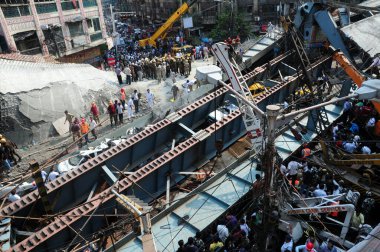 INDIA, Kolkata: Hintli kurtarma görevlileri ve gönüllüler 31 Mart 2016 'da Kolkata' da yıkılmış bir üstgeçit köprüsünün enkazının yanında bir ceset taşıdılar 
