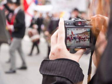 Arka planında kamera olan el.