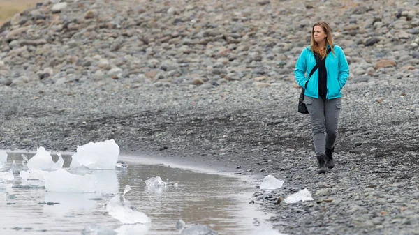手配氷河ラグーン 氷でビーチを歩いている女性 — ストック写真