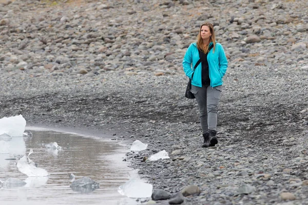 手配氷河ラグーン 氷でビーチを歩いている女性 — ストック写真