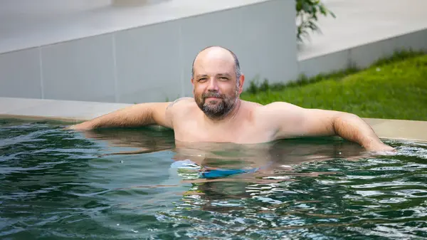 old man in pool outdoor on background