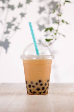 Homemade chocolate milk bubble tea in plastic cups on table