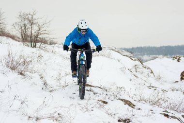 Mavi elbiseli bisikletçi Rocky Winter Hill 'de dağ bisikletiyle dinleniyor. Aşırı spor ve dayanıklı bisiklet konsepti.