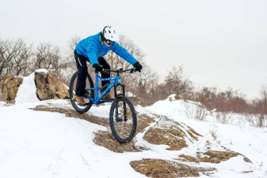 Mavi elbiseli bisikletçi Rocky Winter Hill 'de dağ bisikletiyle dinleniyor. Aşırı spor ve dayanıklı bisiklet konsepti.