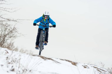 Mavi elbiseli bisikletçi Rocky Winter Hill 'de dağ bisikletiyle dinleniyor. Aşırı spor ve dayanıklı bisiklet konsepti.
