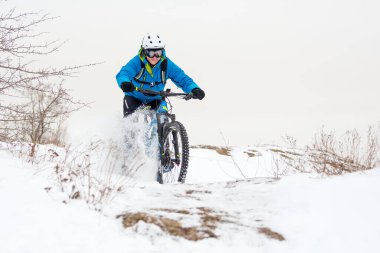 Mavi elbiseli bisikletçi Rocky Winter Hill 'de dağ bisikletiyle dinleniyor. Aşırı spor ve dayanıklı bisiklet konsepti.