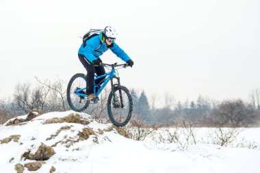 Mavi elbiseli bisikletçi Rocky Winter Hill 'de dağ bisikletiyle dinleniyor. Aşırı spor ve dayanıklı bisiklet konsepti.