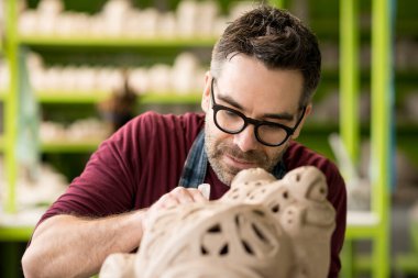 Parlak Seramik Atölyesinde Çamur Heykeli üzerine çalışan Önlük Giyinik Seramik Portresi.