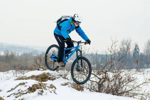 Mavi elbiseli bisikletçi Rocky Winter Hill 'de dağ bisikletiyle dinleniyor. Aşırı spor ve dayanıklı bisiklet konsepti.
