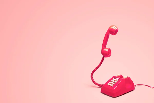 レトロピンクの背景にレトロピンクの電話 — ストック写真