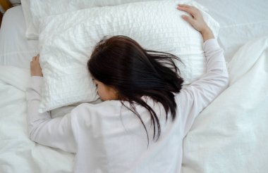 Genç Asyalı kadın yatakta. Uyurken sağlık kavramı